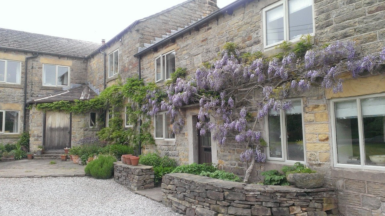 Loadbrook Cottage – exterior view with purple flowers hanging across the front of the building