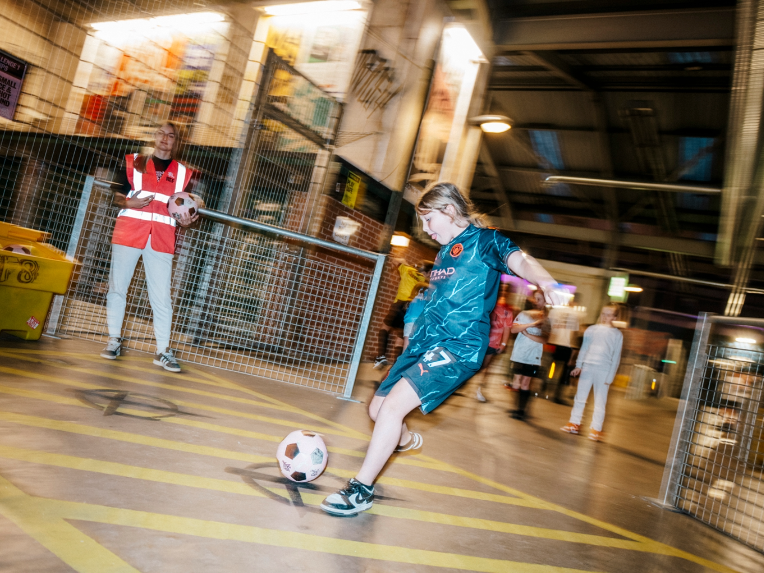 Children playing football at Yard Ball, an indoor football park.