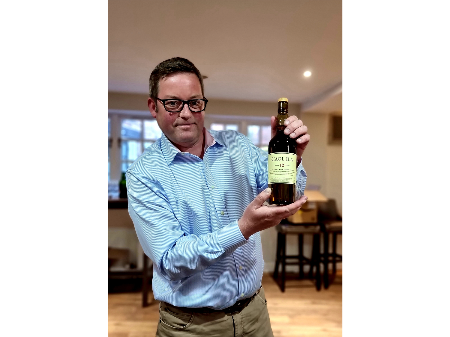 Islay Distiller David Wood holding a bottle of single malt whiskey.