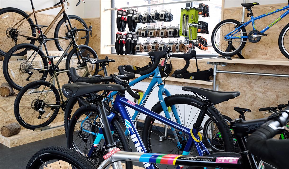 The interior of a shop filled with bikes and cycling equipment on display.