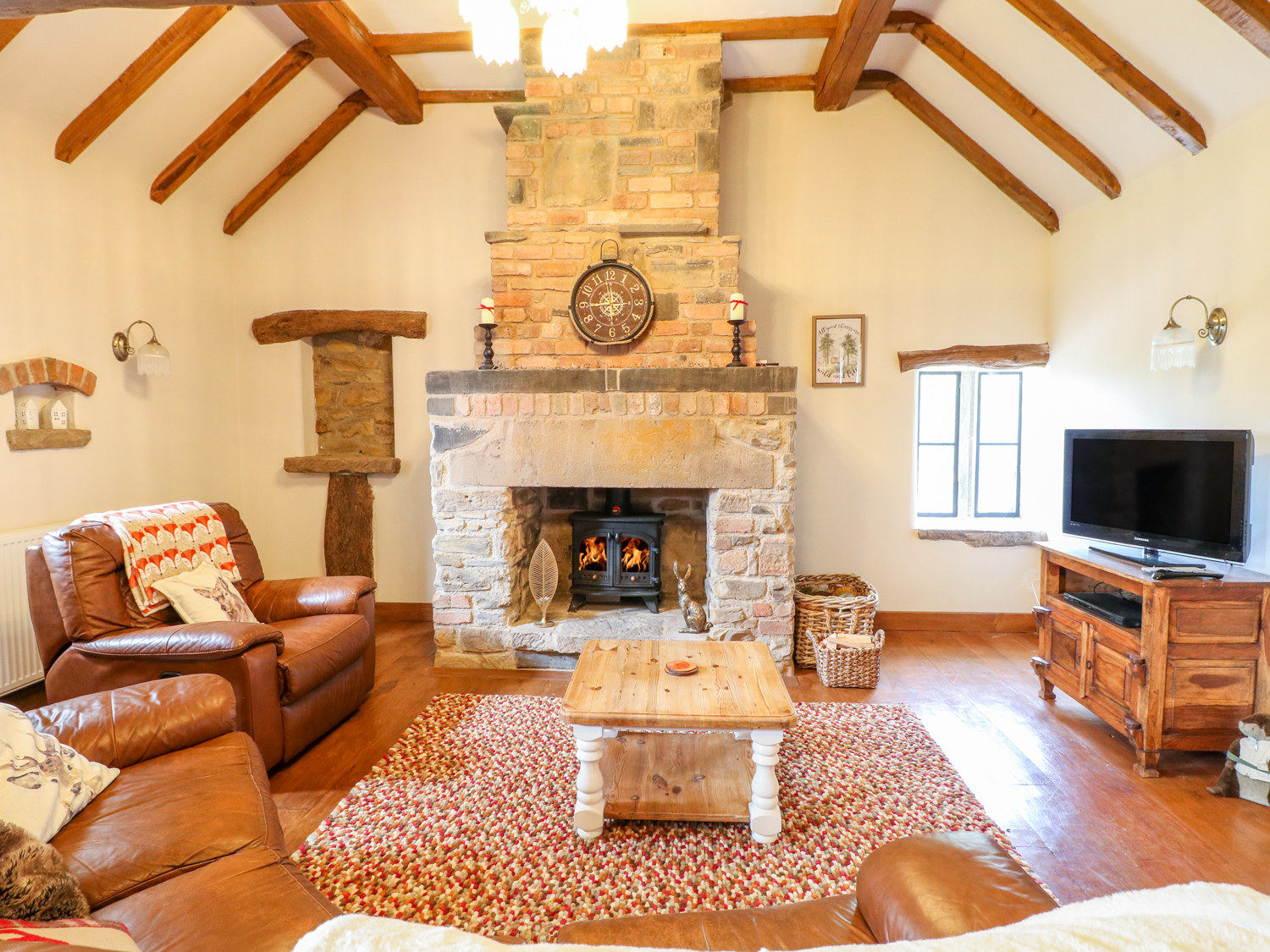 Comfortable living room in a Sykes Holiday Cottage with sofa and television.