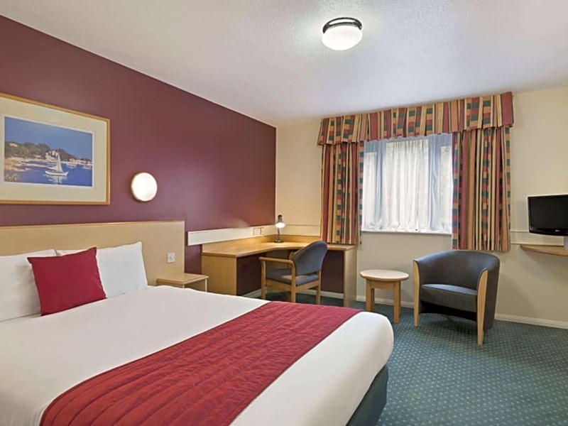 Bedroom featuring a double bed positioned near a window with natural light.