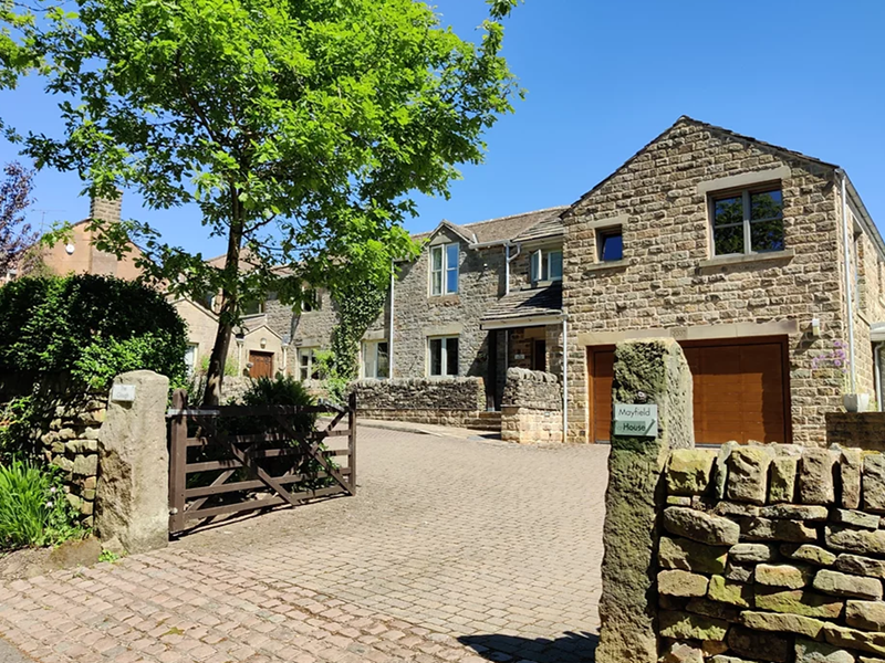 Exterior view of The Clough, a traditional building set in a scenic rural area.