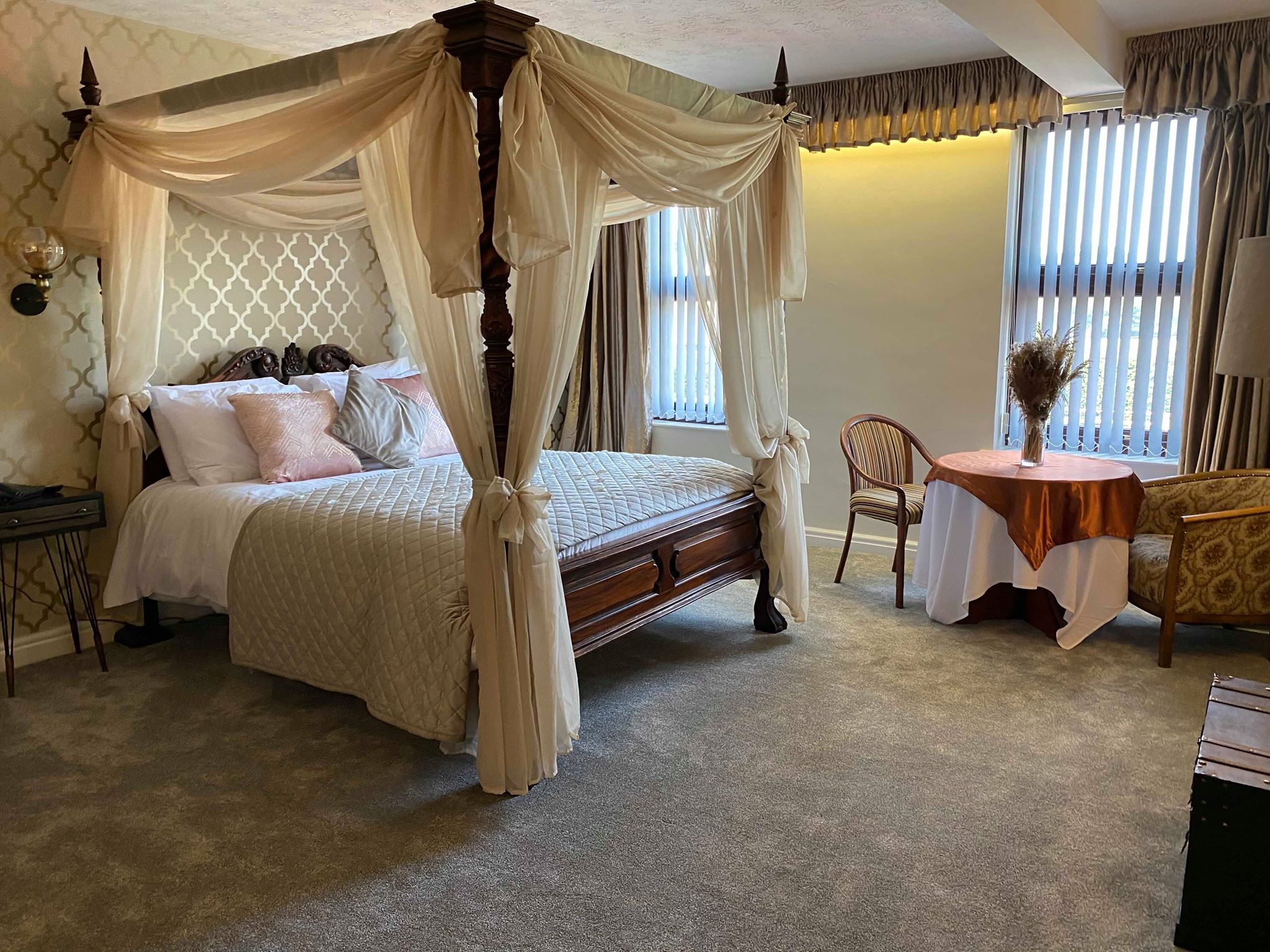 A hotel room with a four poster bed.