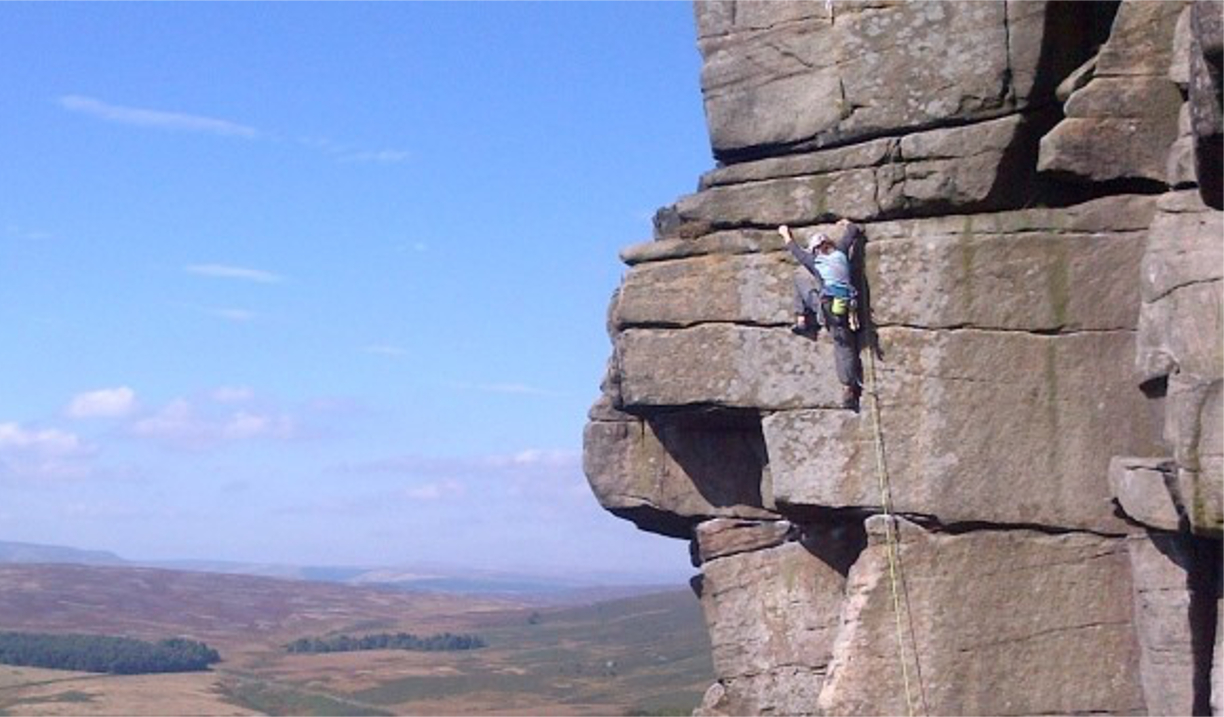 A person scaling a rock face.