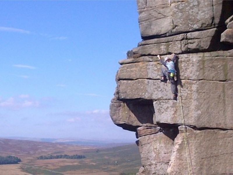 A person scaling a rock face.