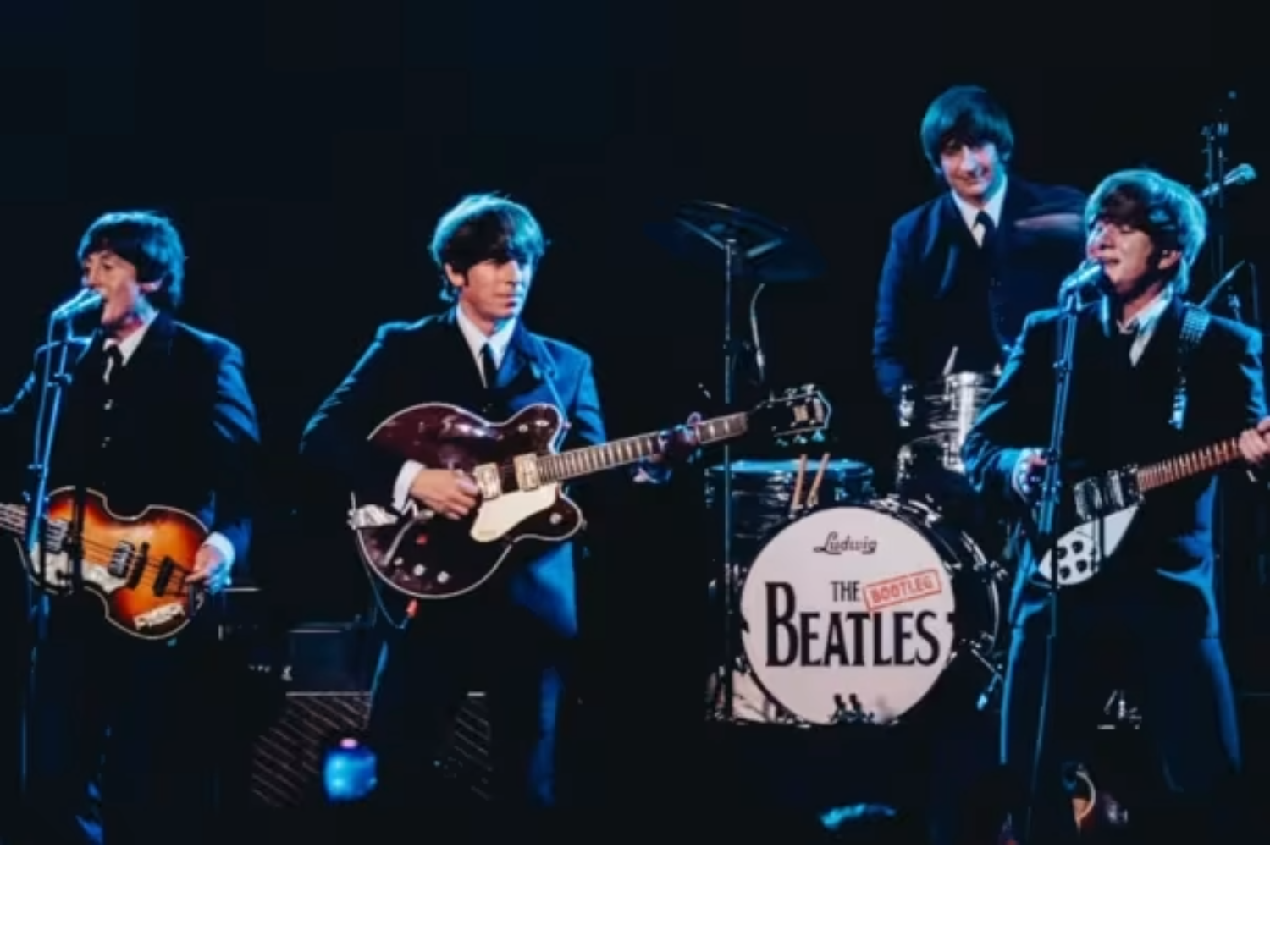 A photograph of The Bootleg Beatles playing live on stage.