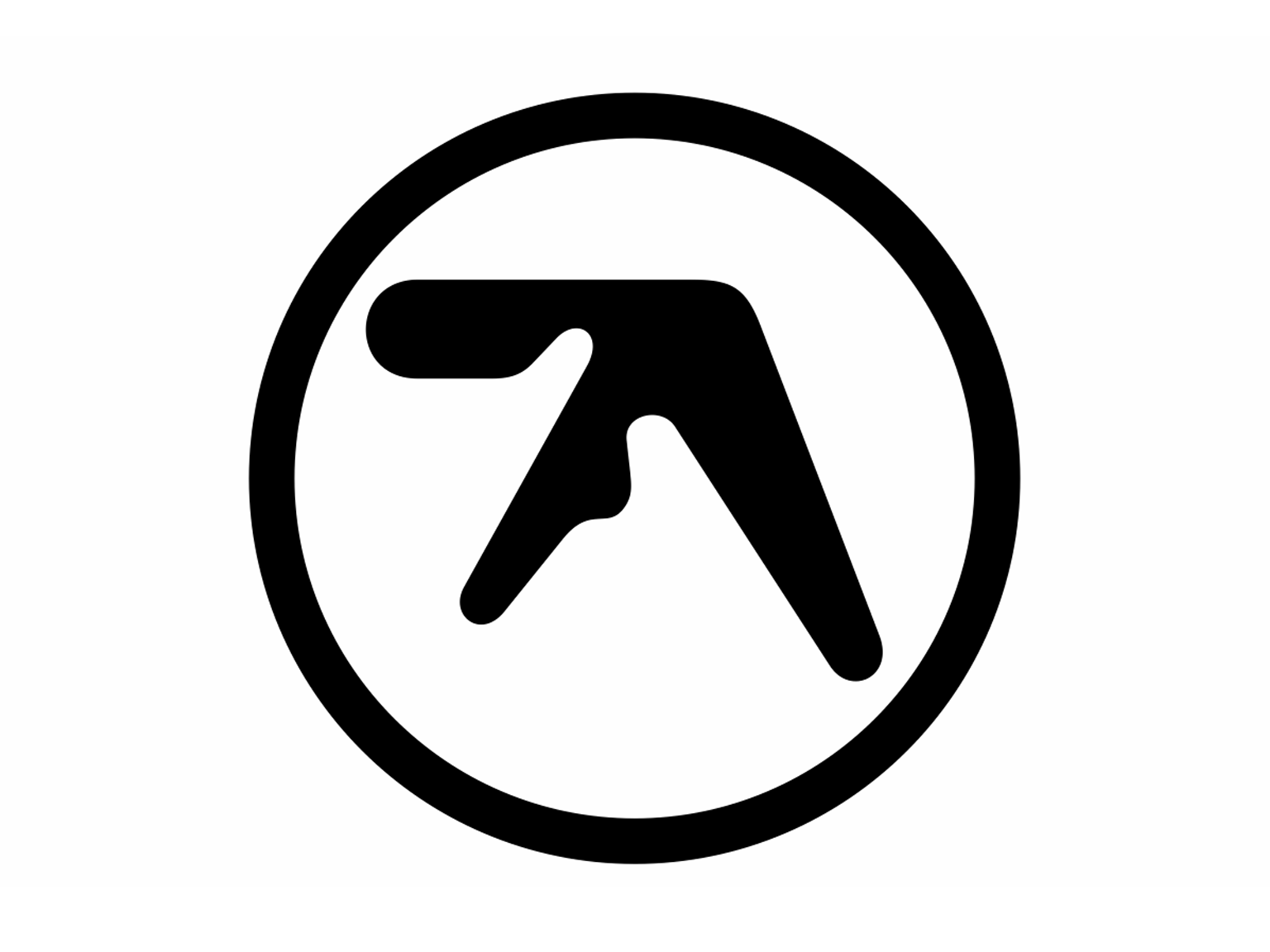 A bold black logo featuring an abstract, angular shape enclosed within a thick circular border. The design is minimalist and geometric, with sharp lines and a distinctive asymmetrical form. The background is plain white, emphasizing the high-contrast black symbol. This is the iconic logo associated with Aphex Twin.