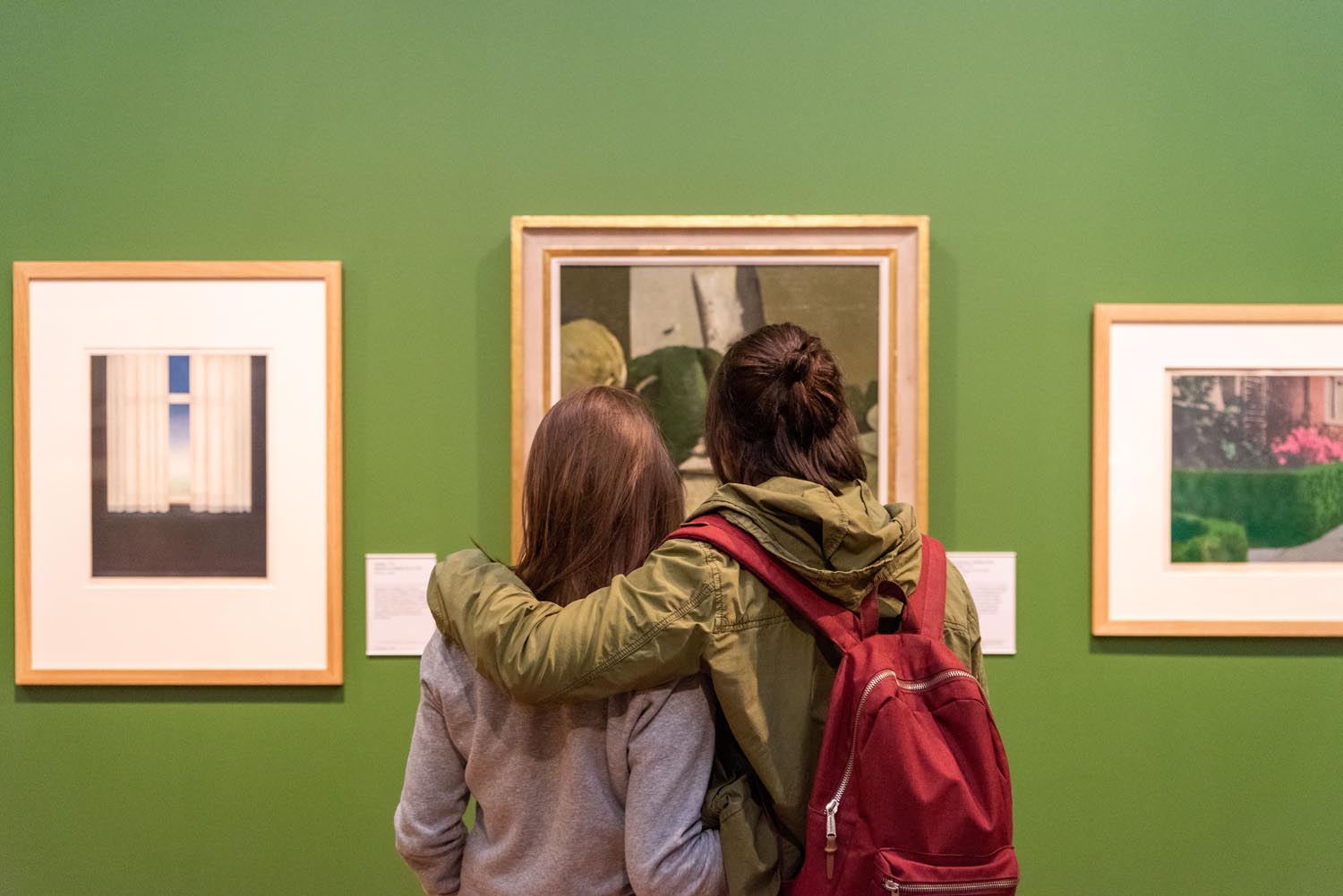 Two people looking at a painting inside Graves Gallery.