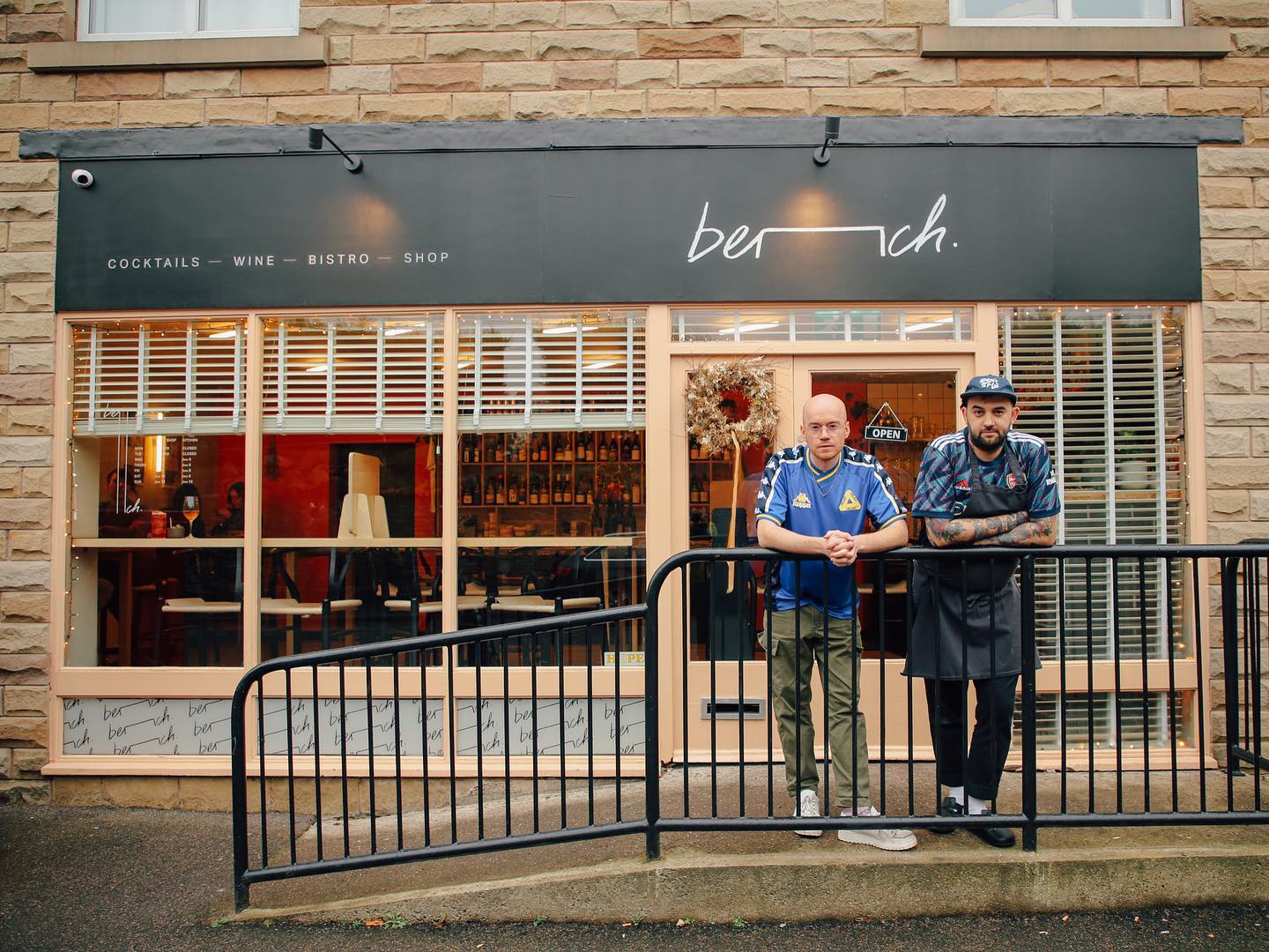 Two men lean on a railing outside the restaurant Bench in Sheffield.