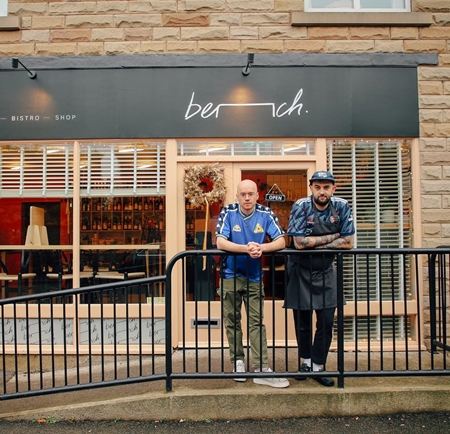 Two men lean on a railing outside the restaurant Bench in Sheffield.