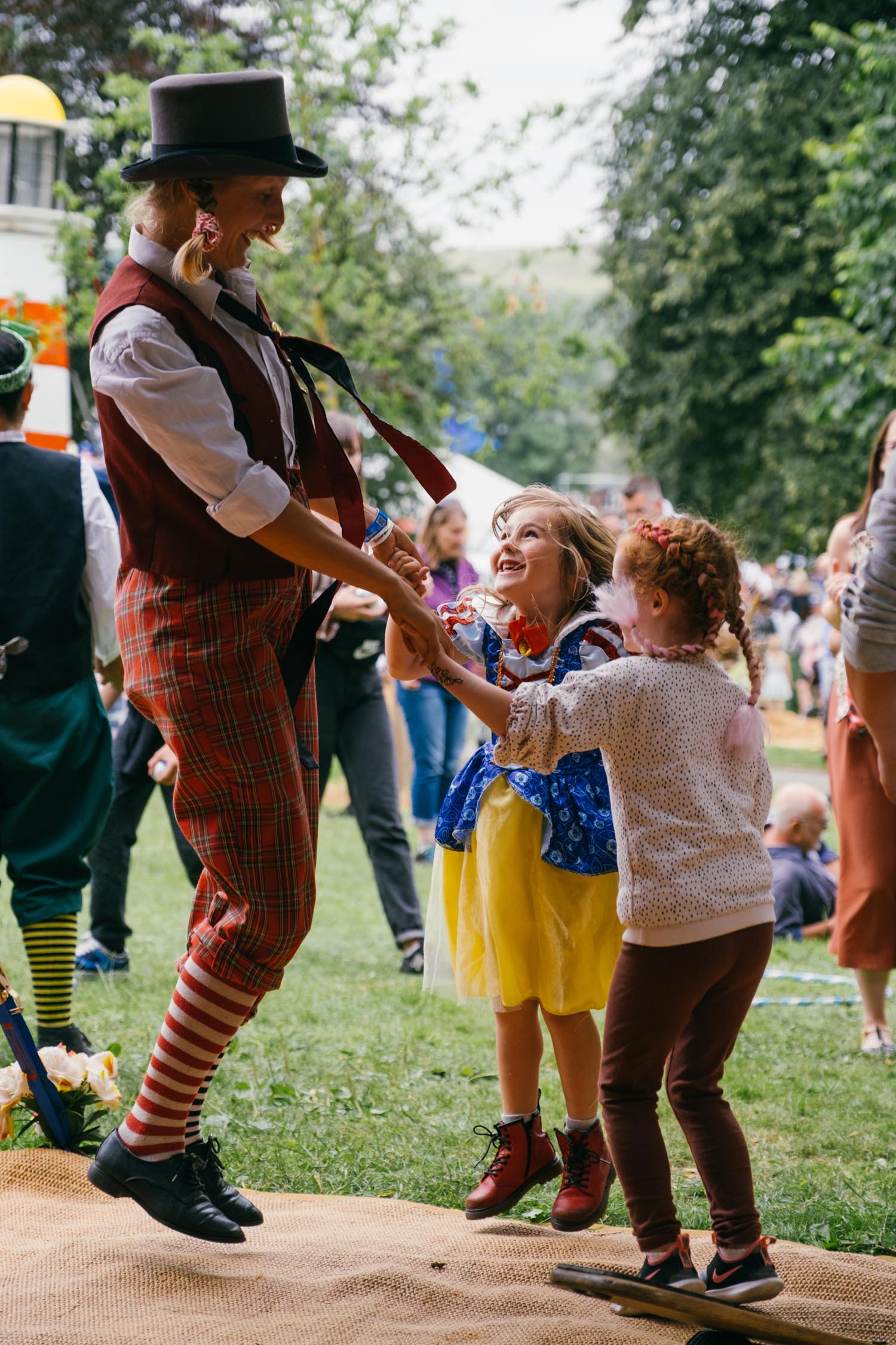 Two children dancing with a clown at the Tramlines Festival.