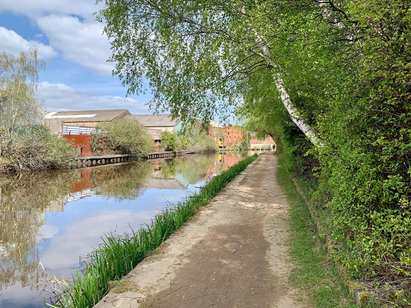 A tow path runs along the side of an inner city canal.