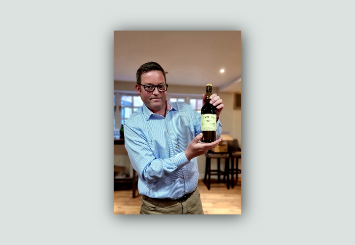 Islay Distiller David Wood holding a bottle of single malt whiskey.