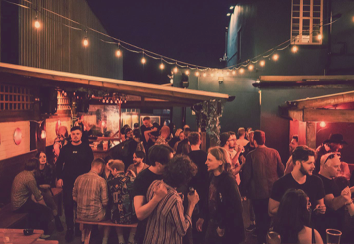 The beer garden at The Washington, filled with customers, at night.