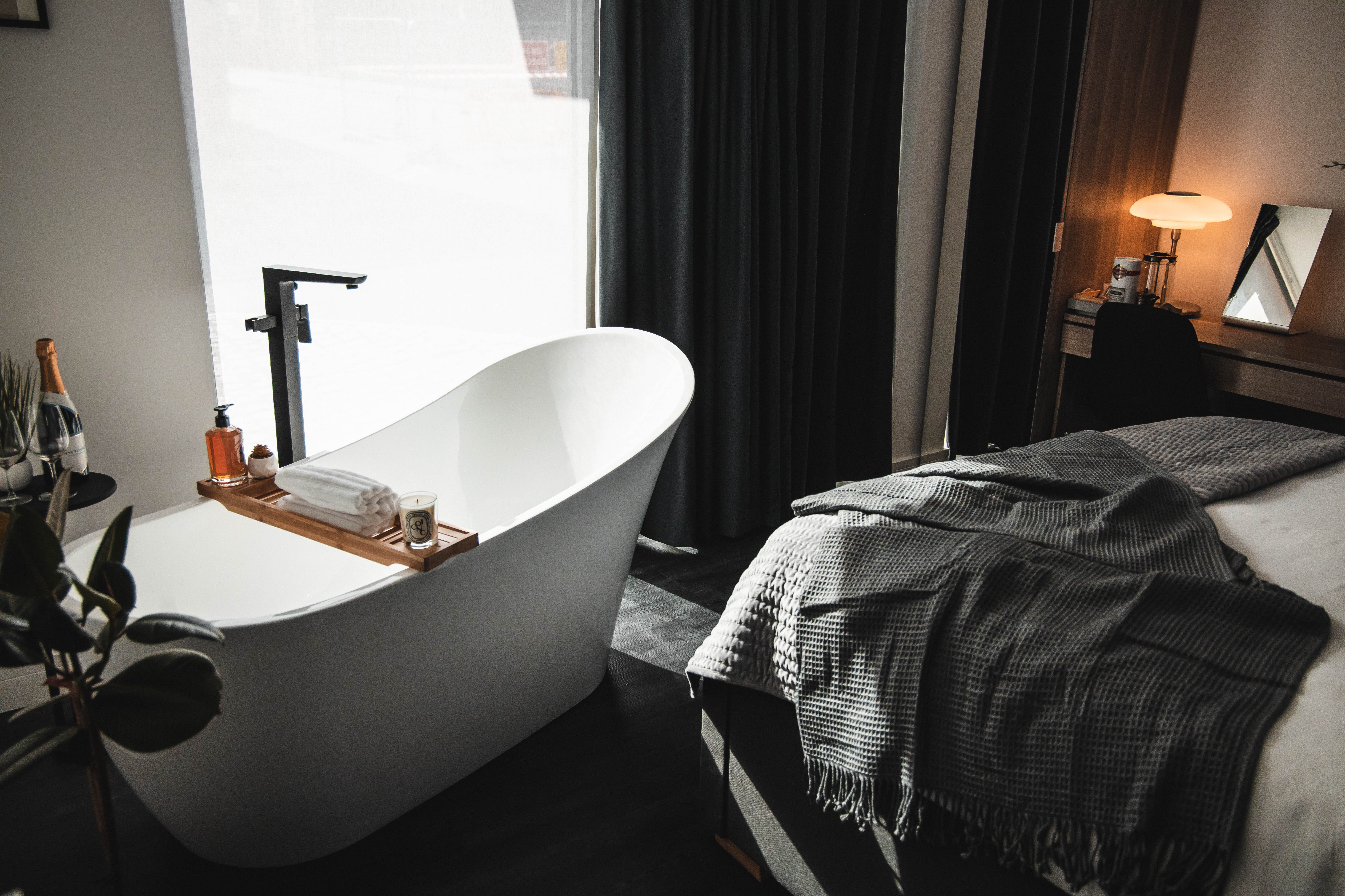 A bedroom with a free standing bath.