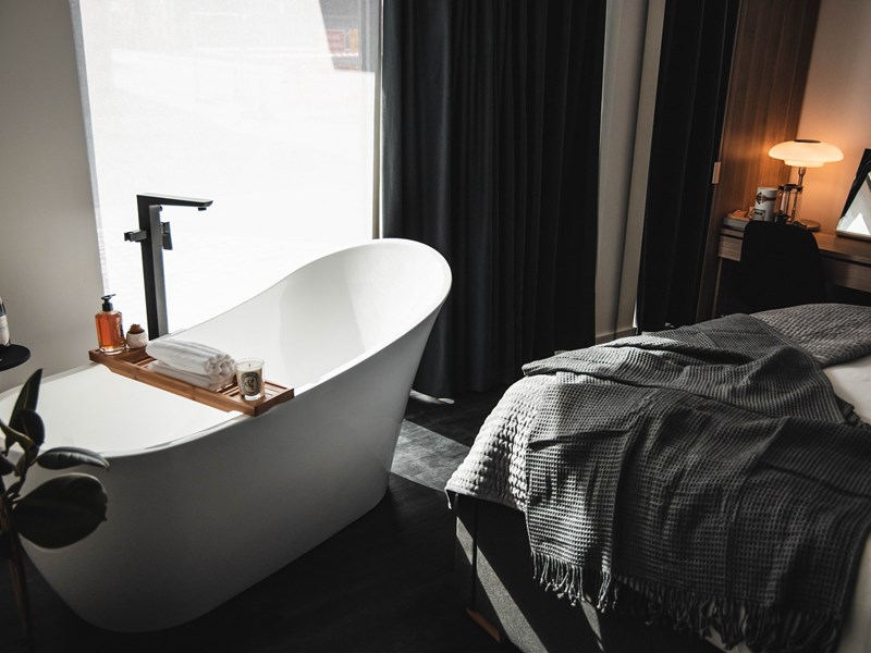 A bedroom with a free standing bath.