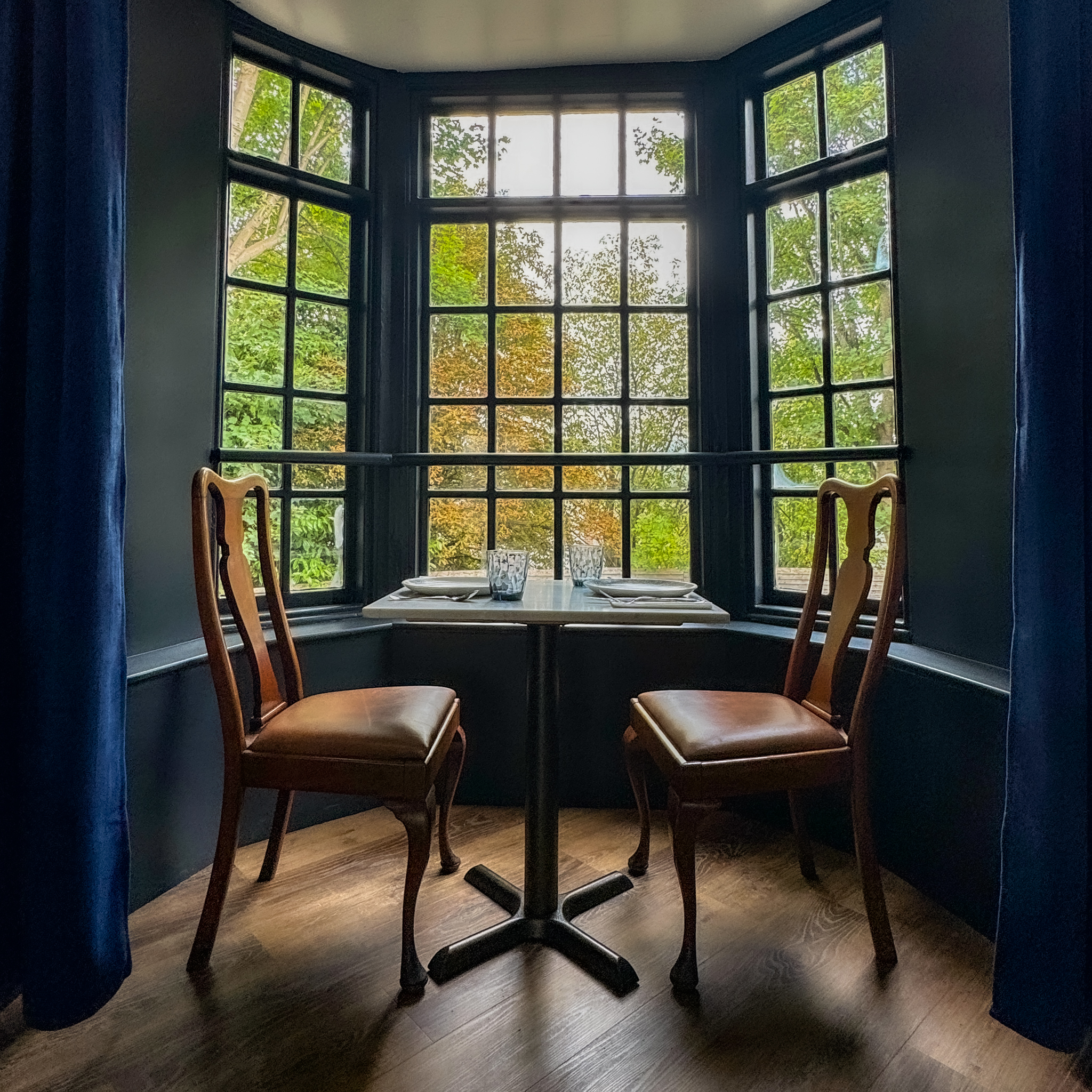 A bay window with a table and two chairs.