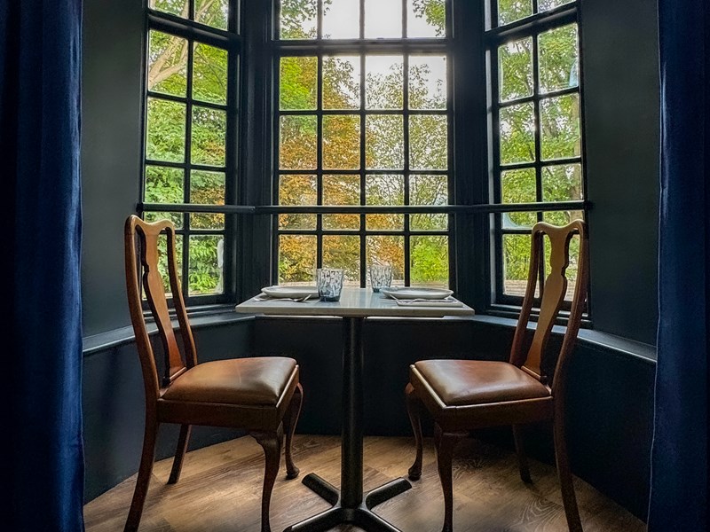 A bay window with a table and two chairs.