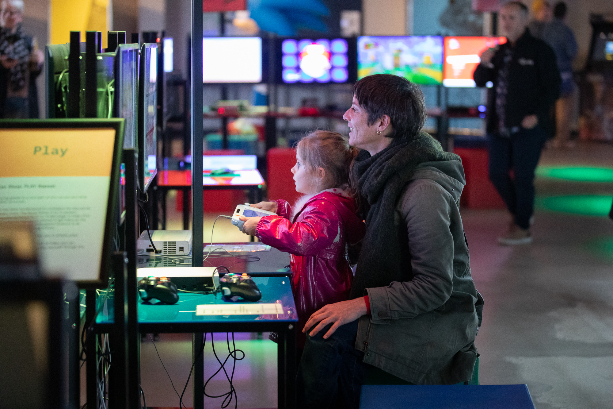 A child sits on their mothers lap, playing a video game at the National Videogame Museum in Sheffield.