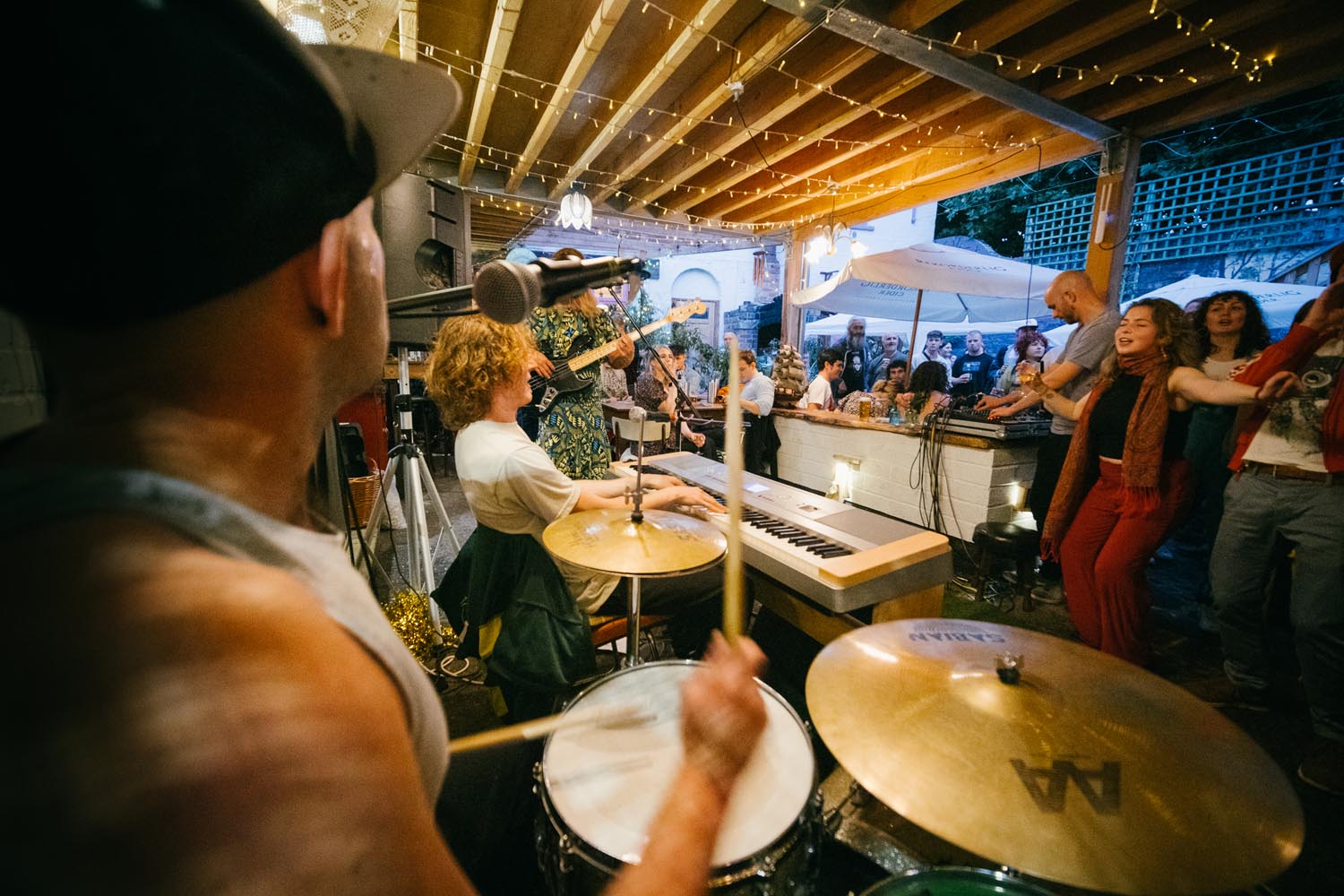 A band plays live on stage in front of a small crowd. 