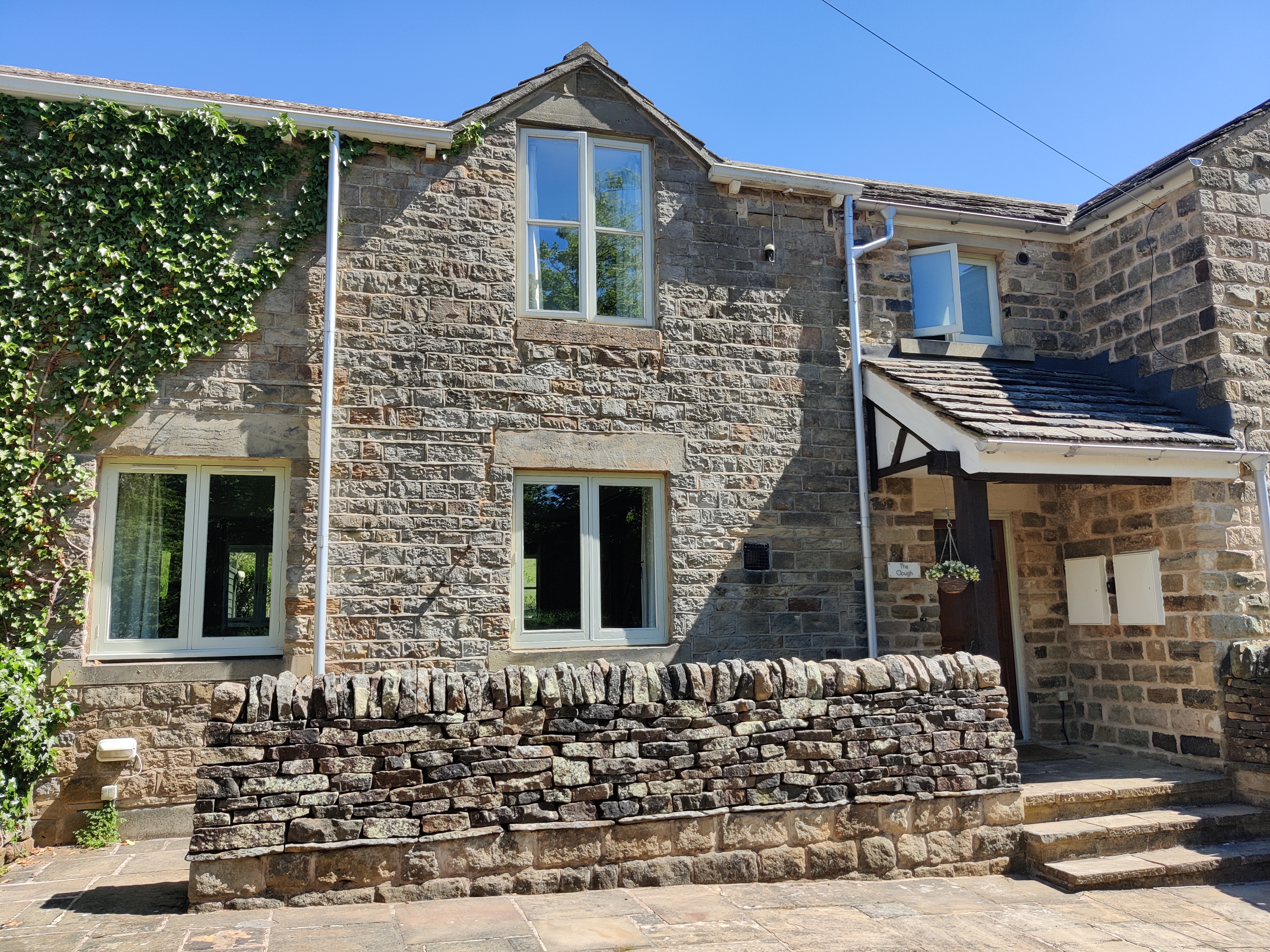 Exterior view of The Clough, a traditional building set in a scenic rural area.