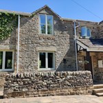 Exterior view of The Clough, a traditional building set in a scenic rural area.