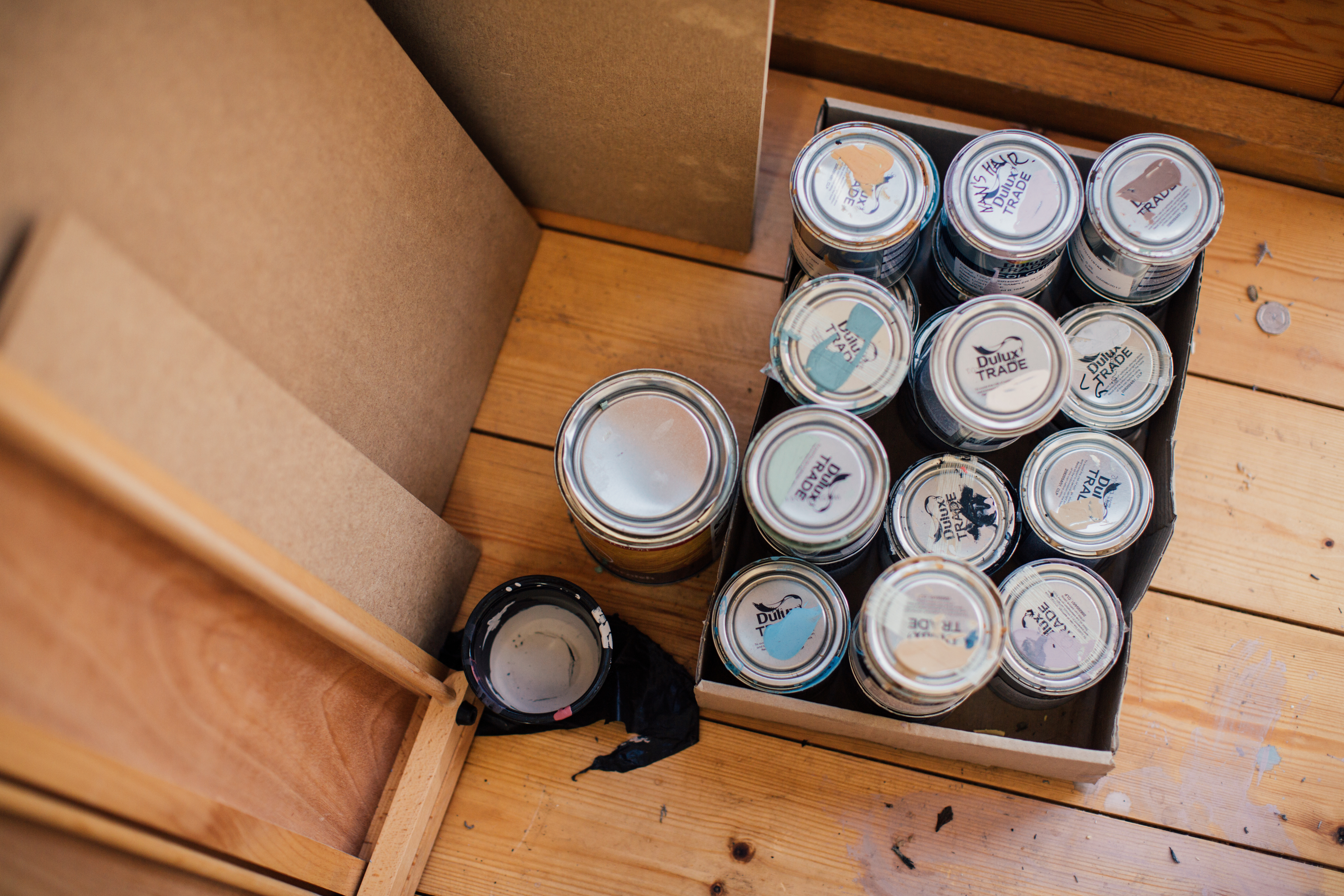 Tins of paint on a wooden floor at the Pete Mckee Gallery.