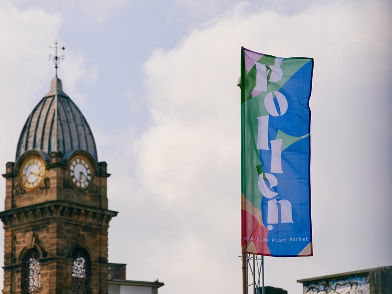 Pollen Market branded flag in front of clock tower
