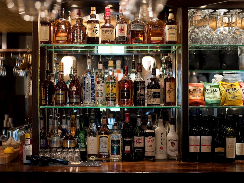 Shelves of spirits and bar snacks behind the bar at The British Oak.