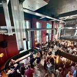 Looking down on lots of people drinking and socialising at Kapital Sheffield beer hall, from the upper floor balcony