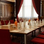Conference room setup with paper, pens, and water bottles on the table.