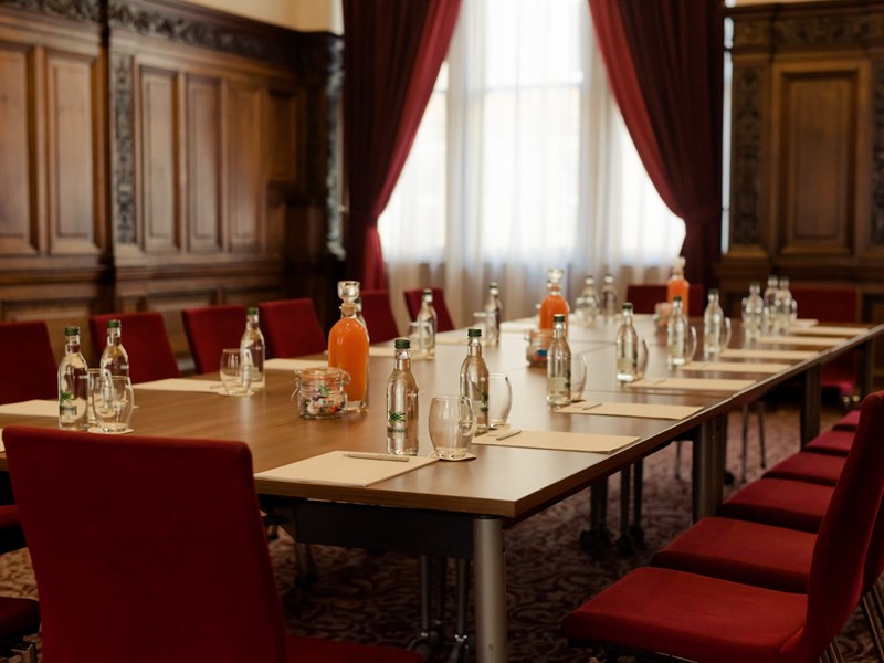 Conference room setup with paper, pens, and water bottles on the table.