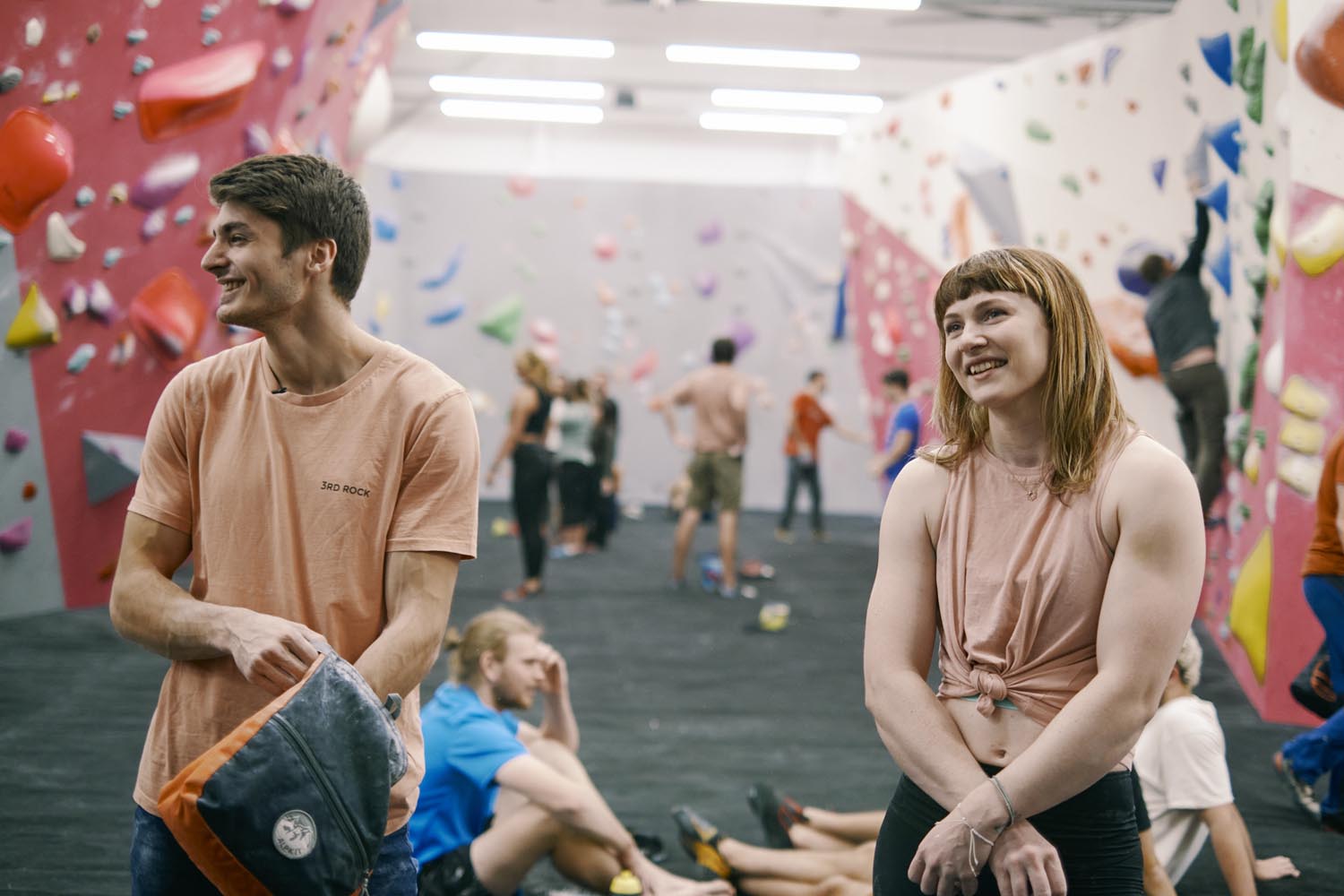 People having fun at an indoors climbing wall.
