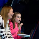 A mother and daughter playing a video game and having fun at the National Videogame Museum.