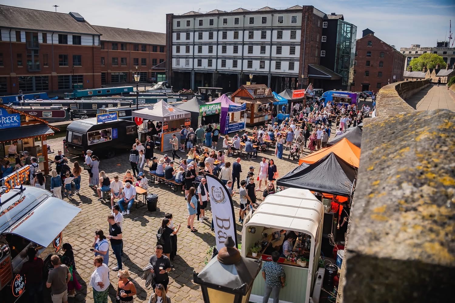 Looking down on the crowds attending Quayside Market in Sheffield on a sunny day 