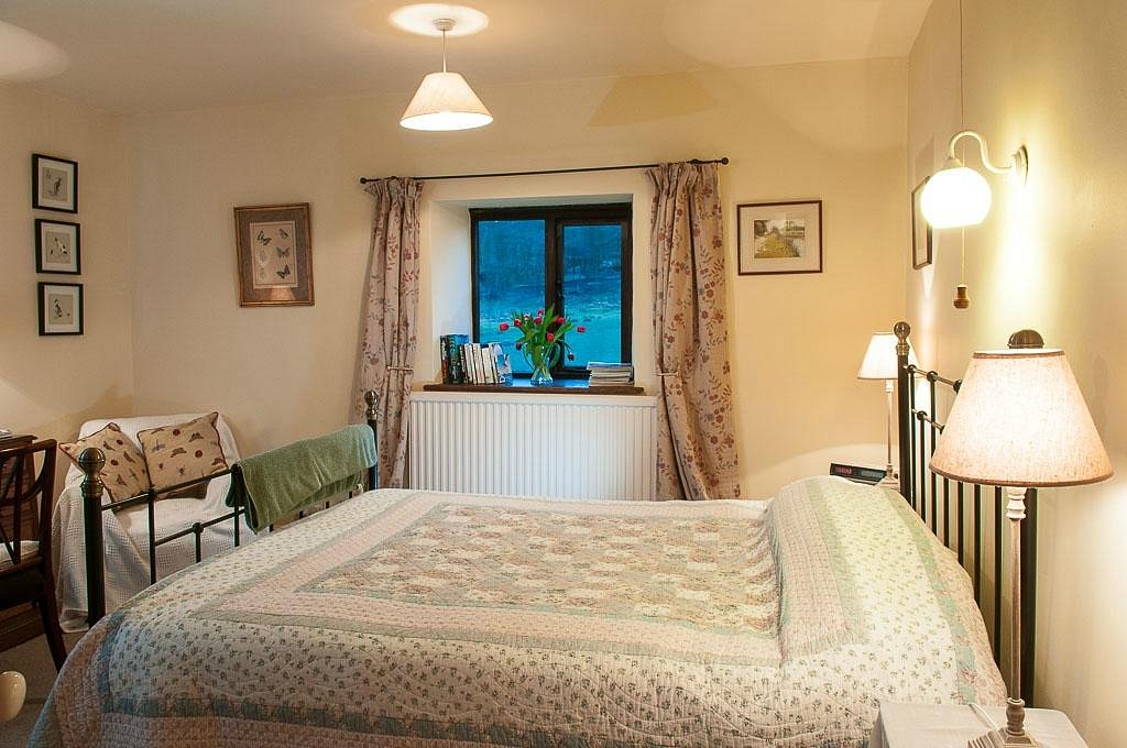 Loadbrook Cottage – double bedroom decorated in cream tones with bed and bedside tables.