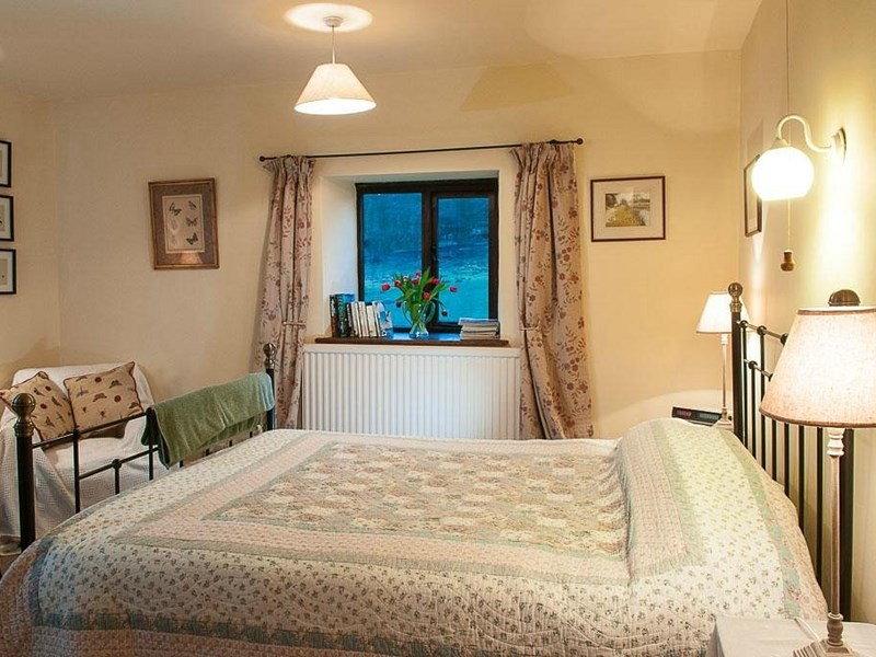 Loadbrook Cottage – double bedroom decorated in cream tones with bed and bedside tables.