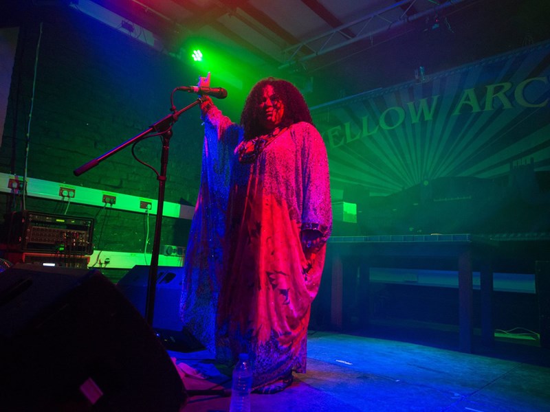 A woman sings live on the stage at Yellow Arch.