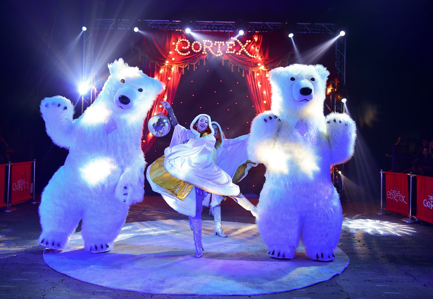 Two circus performers dancing and two people dressed in giant polar bear costumes inside the Big Top at Meadowhall's Magical Winterland 