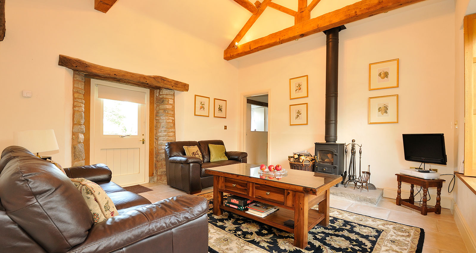 Cozy living room featuring a log burner, sofa, and coffee table.