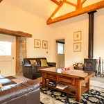 Cozy living room featuring a log burner, sofa, and coffee table.