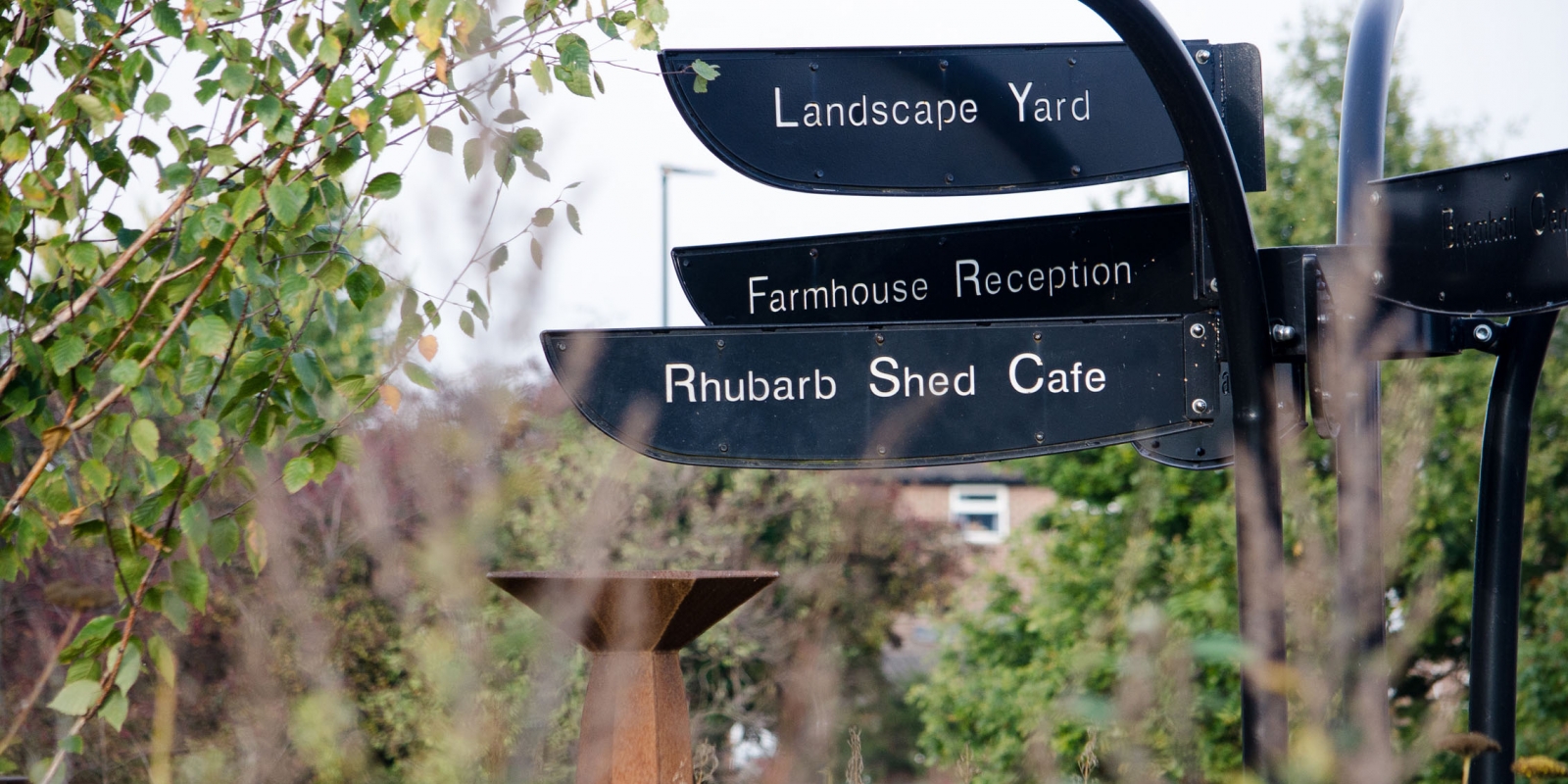 A signpost at Manor Lodge Sheffield, one of which read Rhubarb Shed Cafe.
