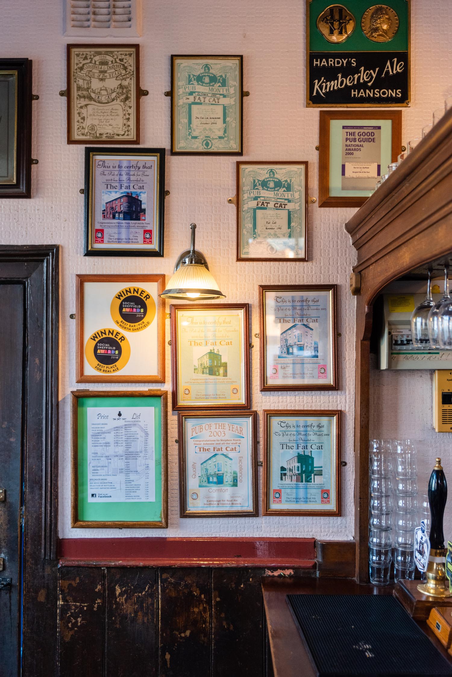 Interior of The Fat Cat; on the wall are lots of picture frames filled with mementos from the pubs past.