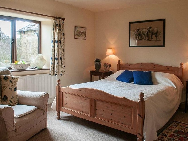 Loadbrook Cottage – double bedroom decorated in brown tones with bed and bedside tables.