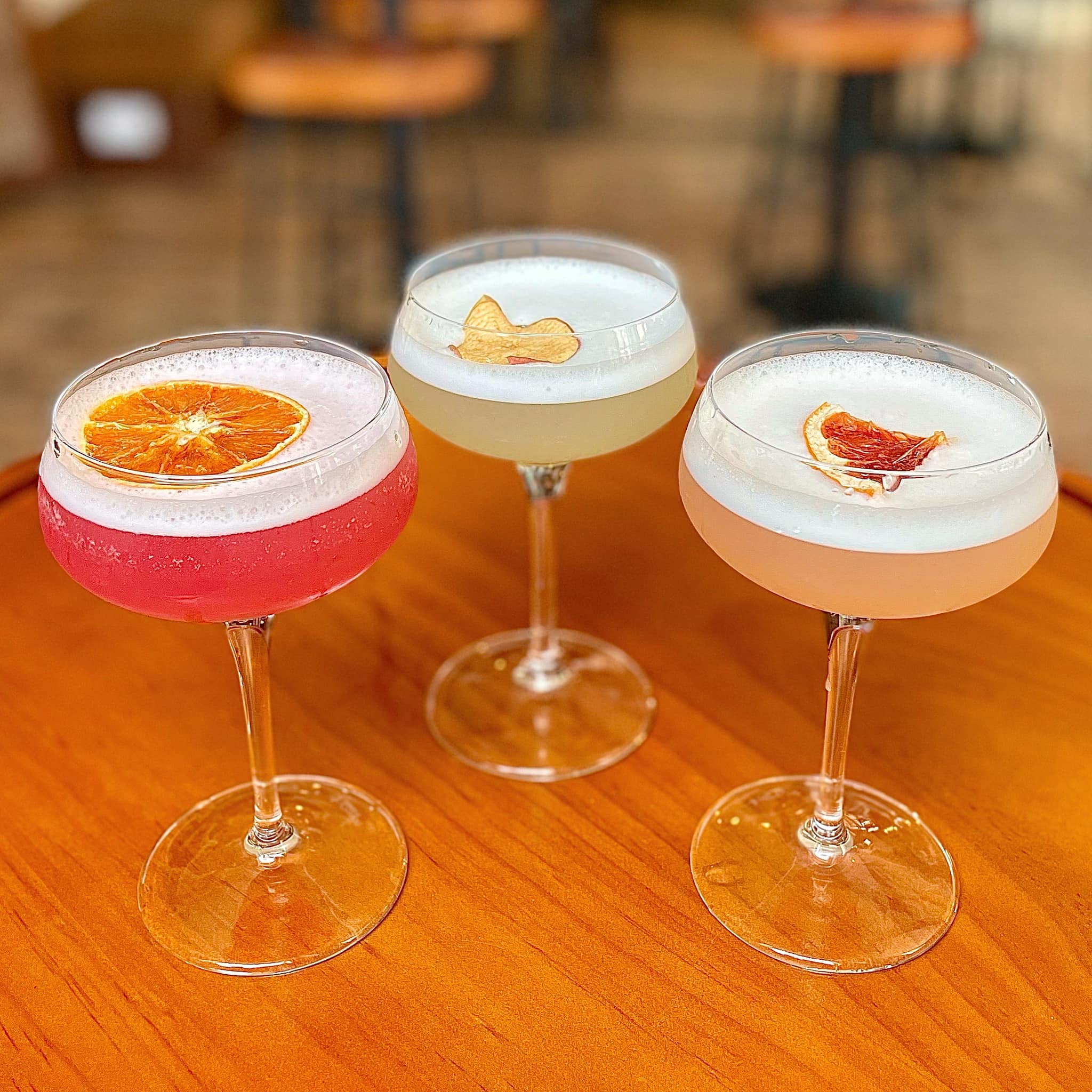 Three different gin cocktails on a table.