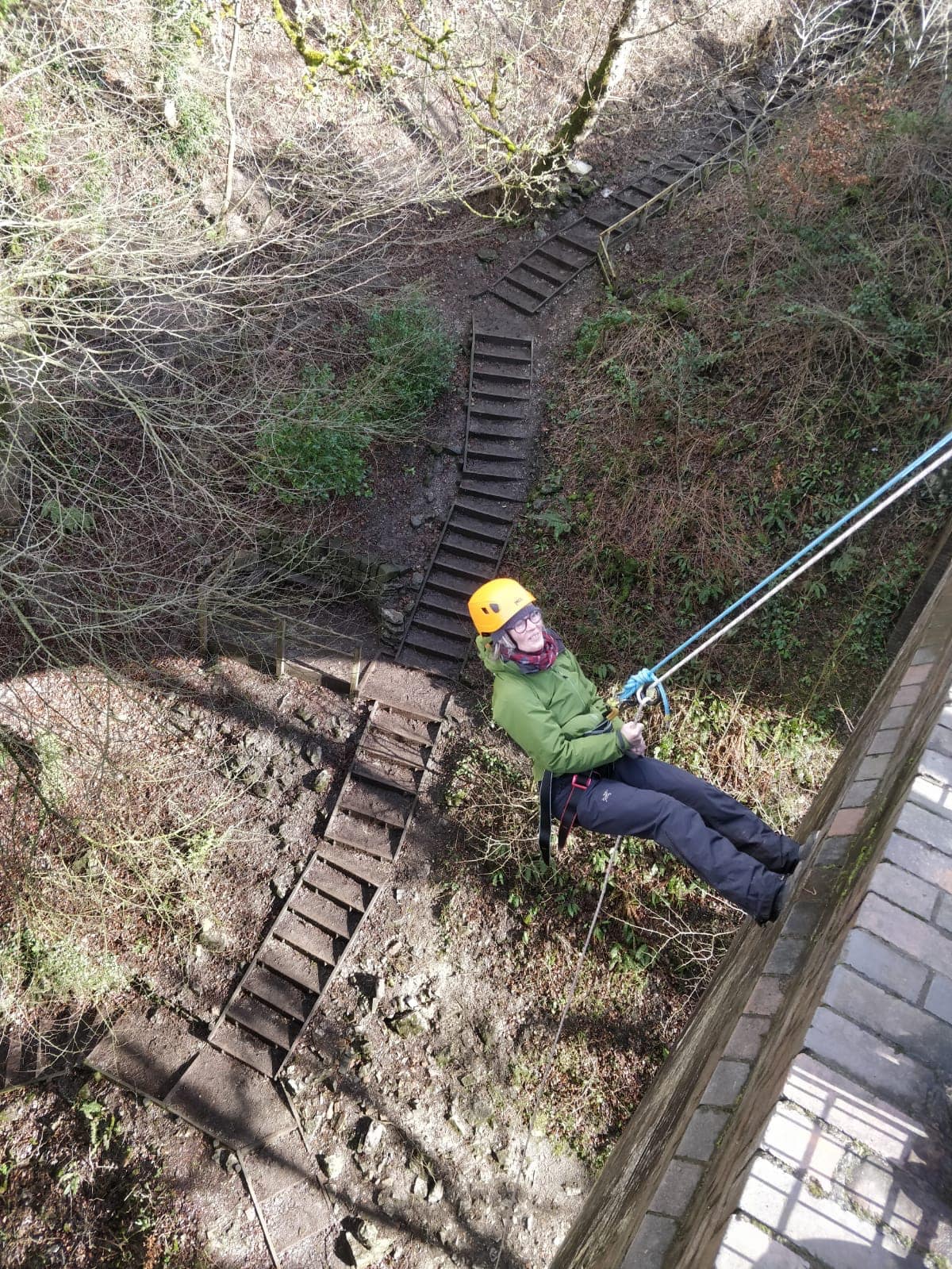 A person abseiling, out in the countryside. 
