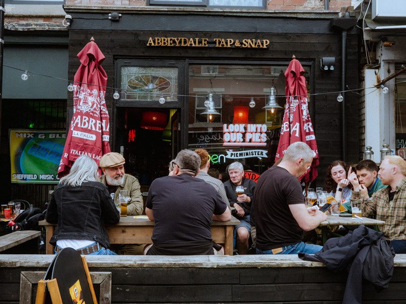 Groups of people sat drinking outside The Abbeydale Tap