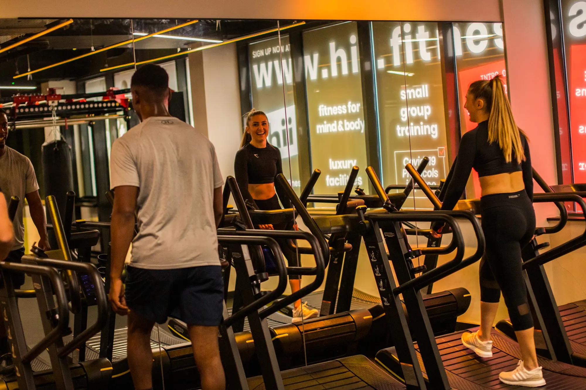 Several people exercising and running machines.