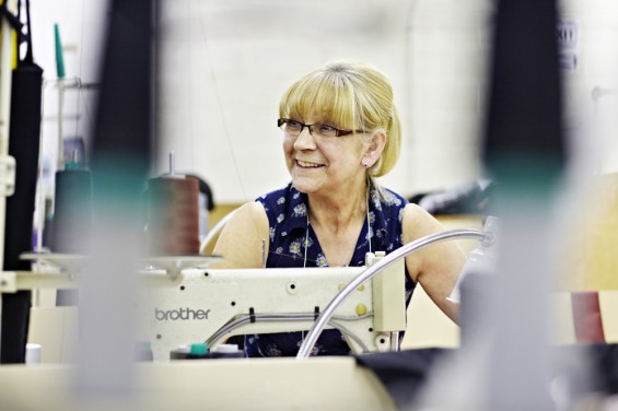 A woman sat at an industrial sewing machine.